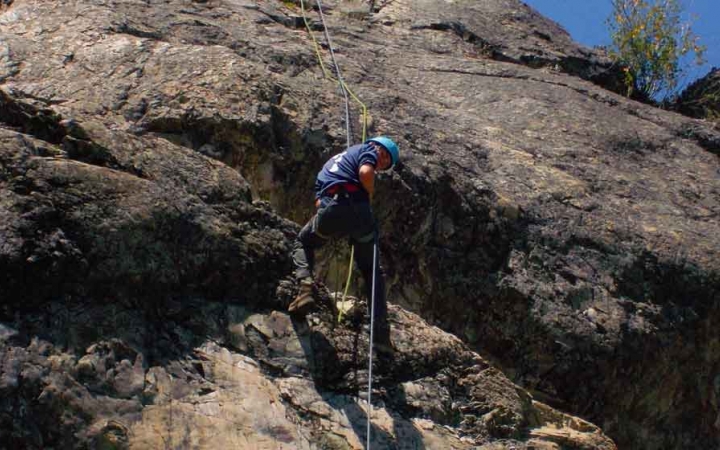 an outward bound student climbs a rock wall on an expedition in the pacific northwest